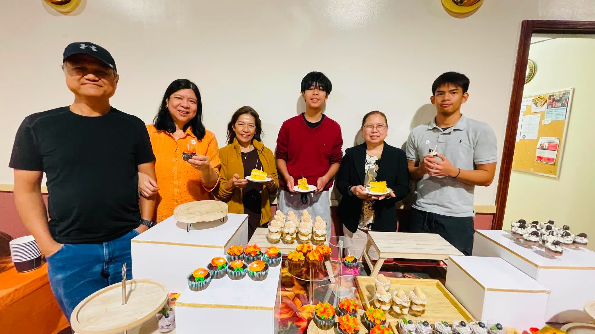 Volunteers standing behind the dessert table they prepared