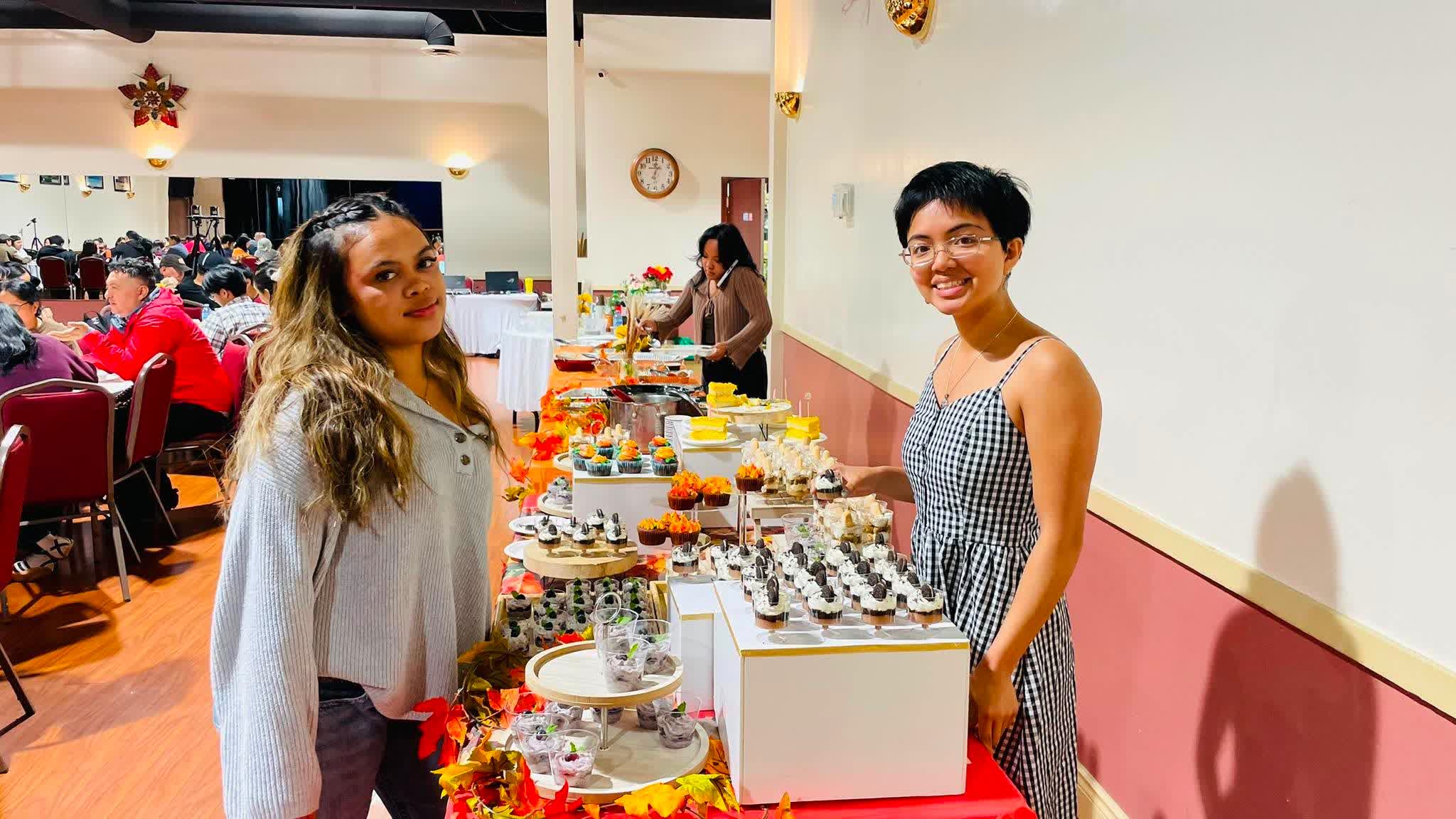 Two young women beside the Thanksgiving dessert table