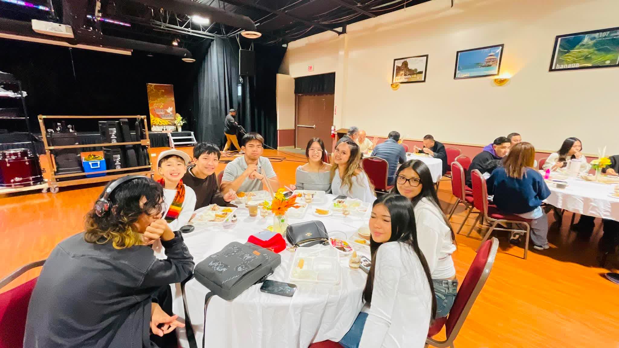 Families and friends gathered around tables in the hall