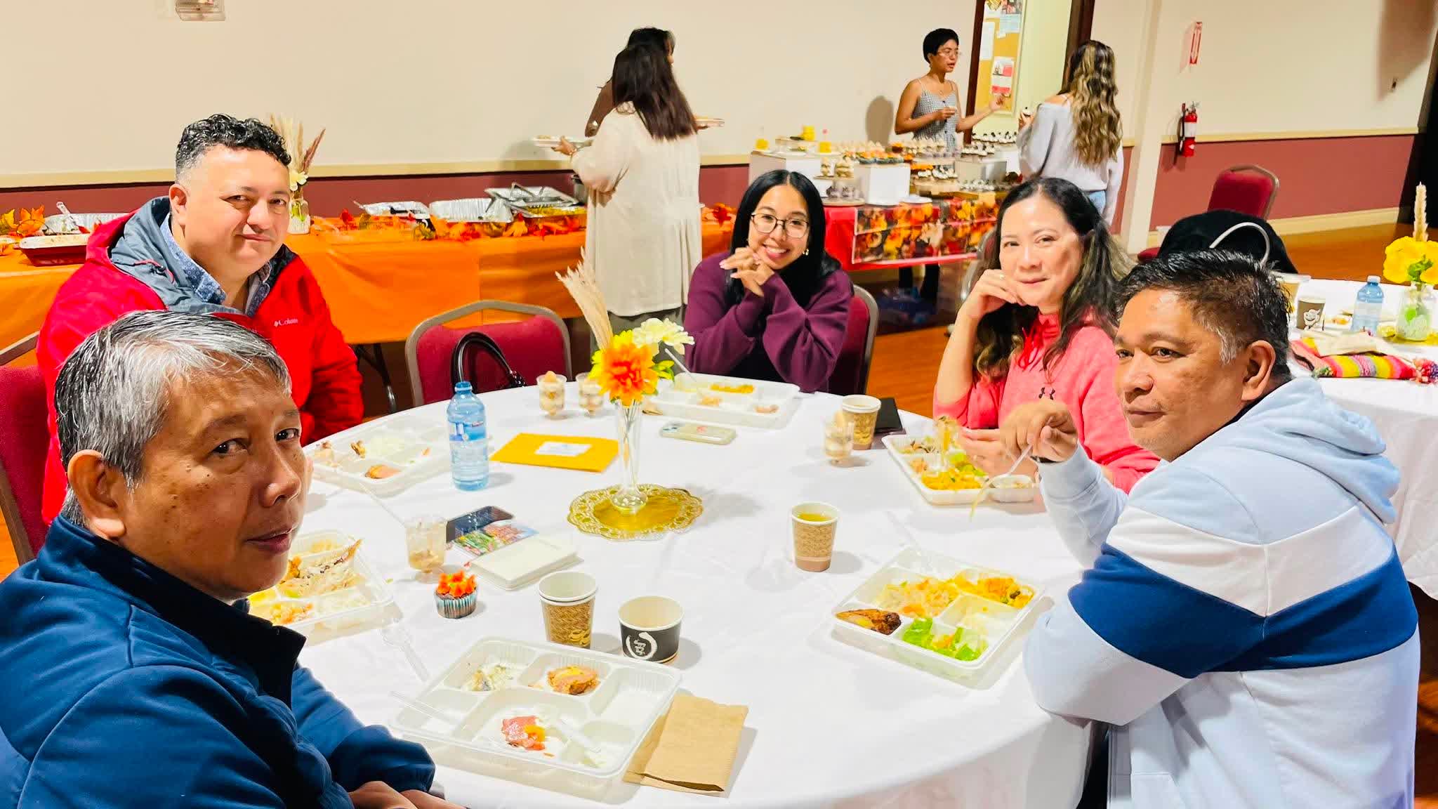 FCC members sharing a meal around a decorated table