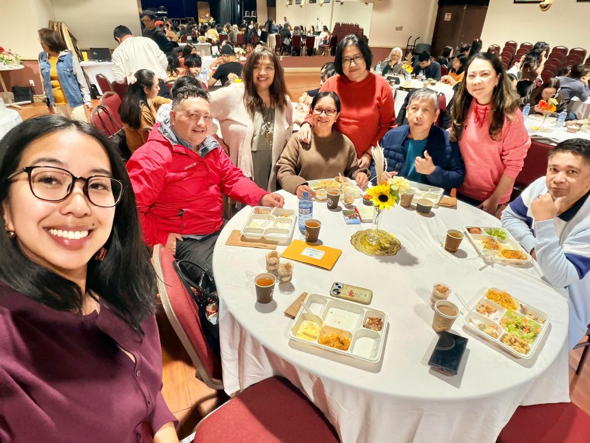 A table of FCC members smiling for a selfie at Thanksgiving dinner