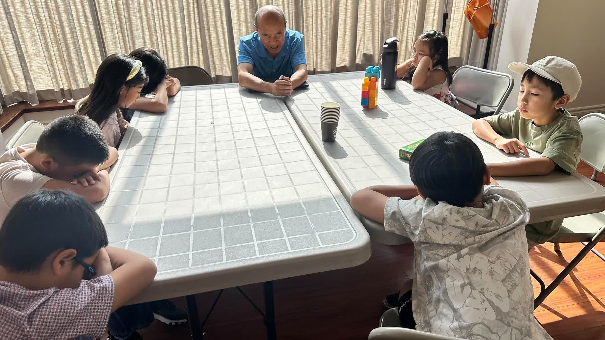 Children praying together with their teacher in Sunday school